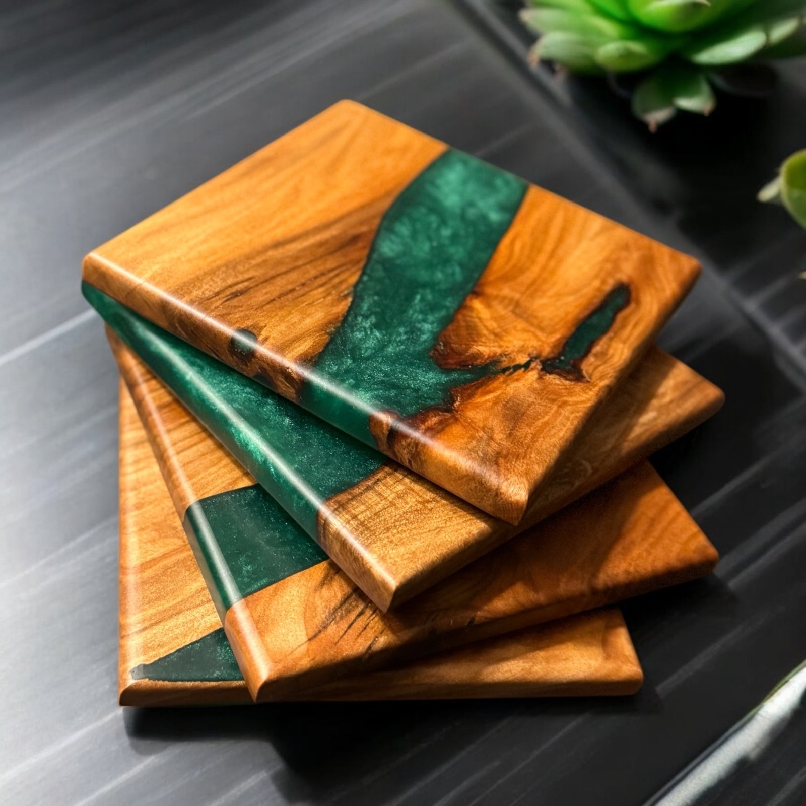 Emerald green epoxy resin and maple wood coasters sitting on an end table