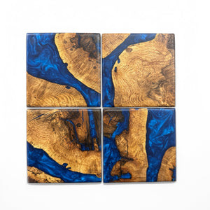 Oak burl coasters with pacific blue resin with a white background.