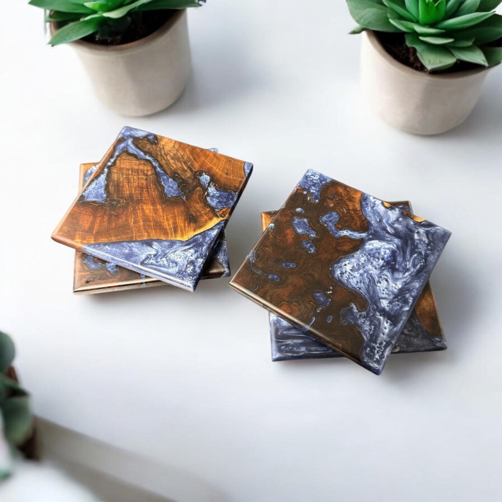 Rare Walnut Burl coasters with Silver blue Resin sitting on a white table.