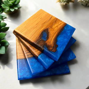 Maui blue epoxy resin and hickory wood coasters sitting on white countertop