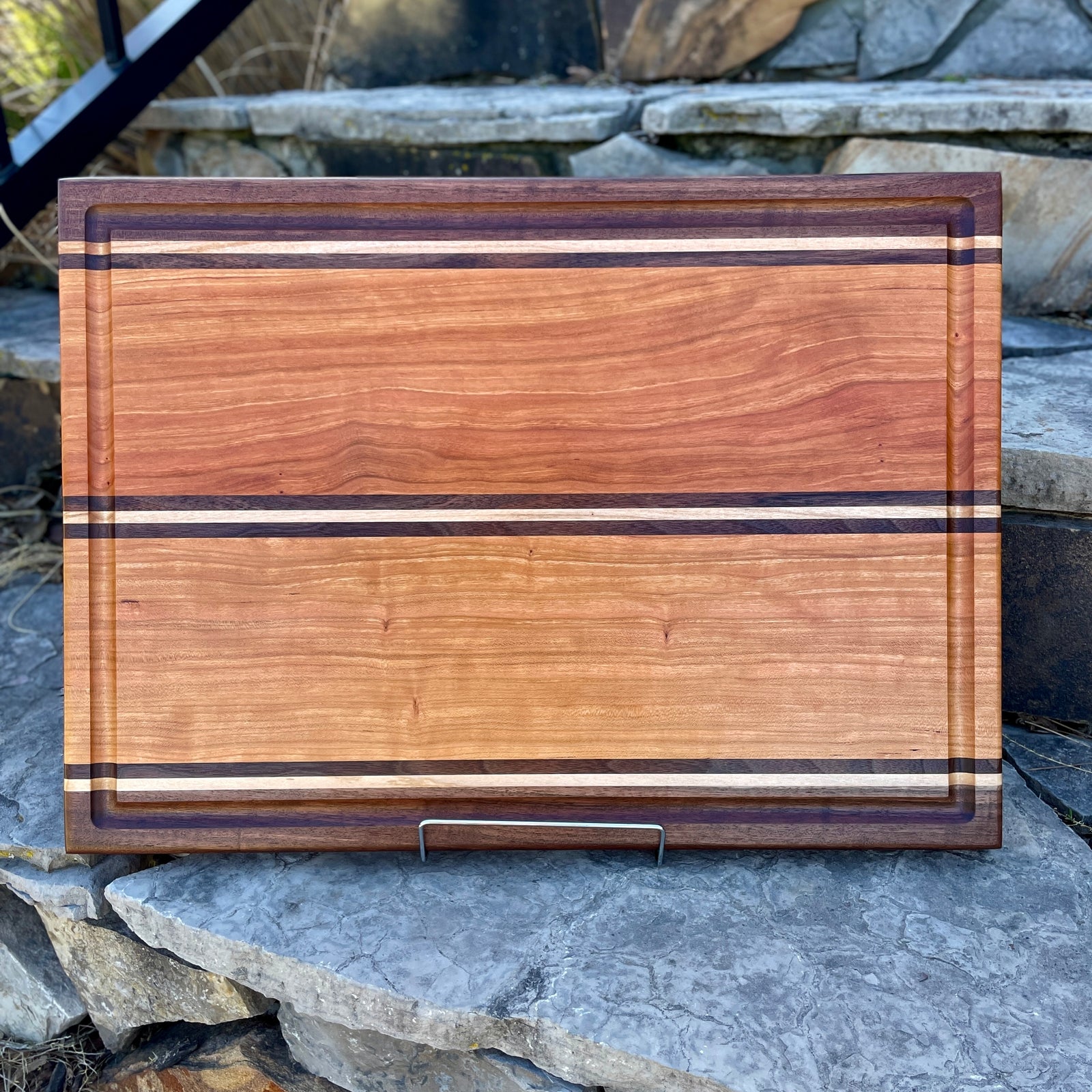 cherry cutting board with maple and walnut inlays. This board is very unique and perfect for your next grilling venture.