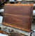 A walnut, zebrawood and wenge edge grain cutting board with a stone background