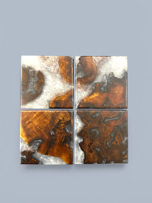 Walnut burl coasters with ghost resin with a gray background.