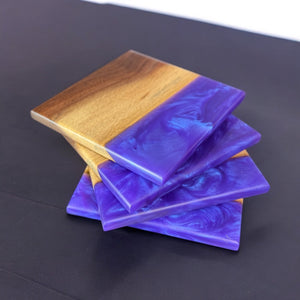 Reef Epoxy resin and walnut wood coasters on a dark wood countertop.